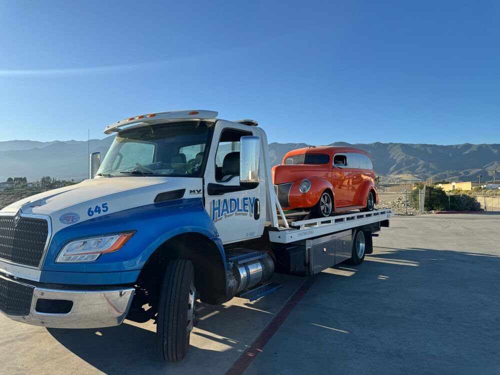 Hadley 645 flatbed with orange classic car on deck
