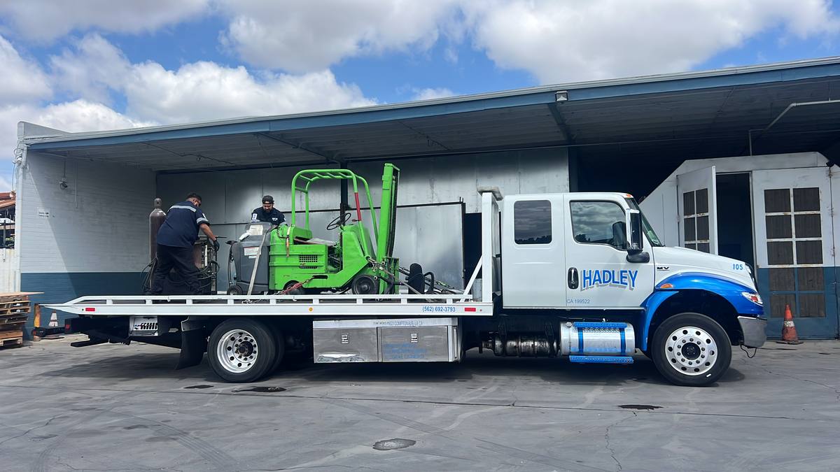Hadley flatbed transporting a forklift