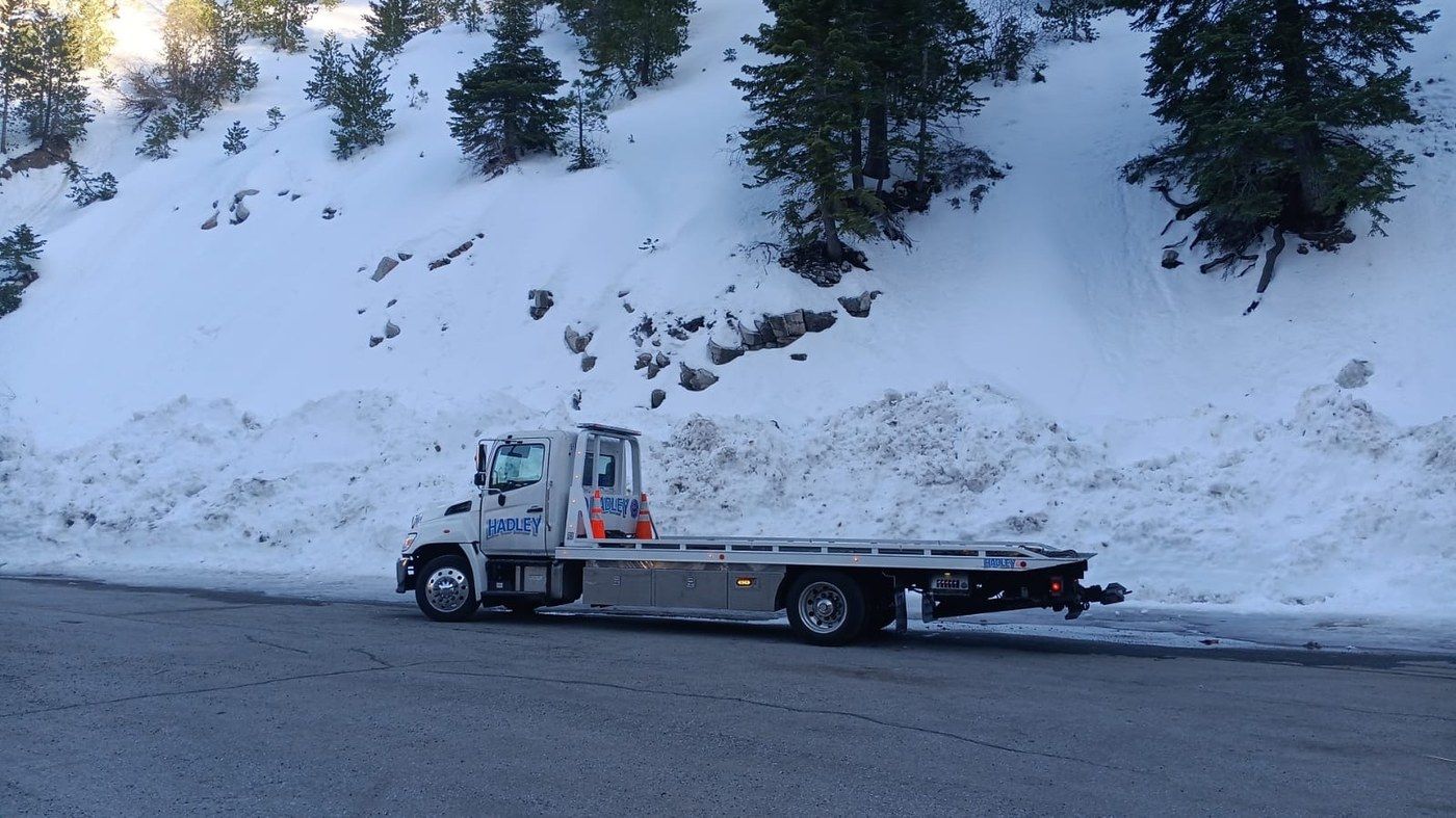 Hadley Tow flatbed parked on a snowy SoCal mountain road