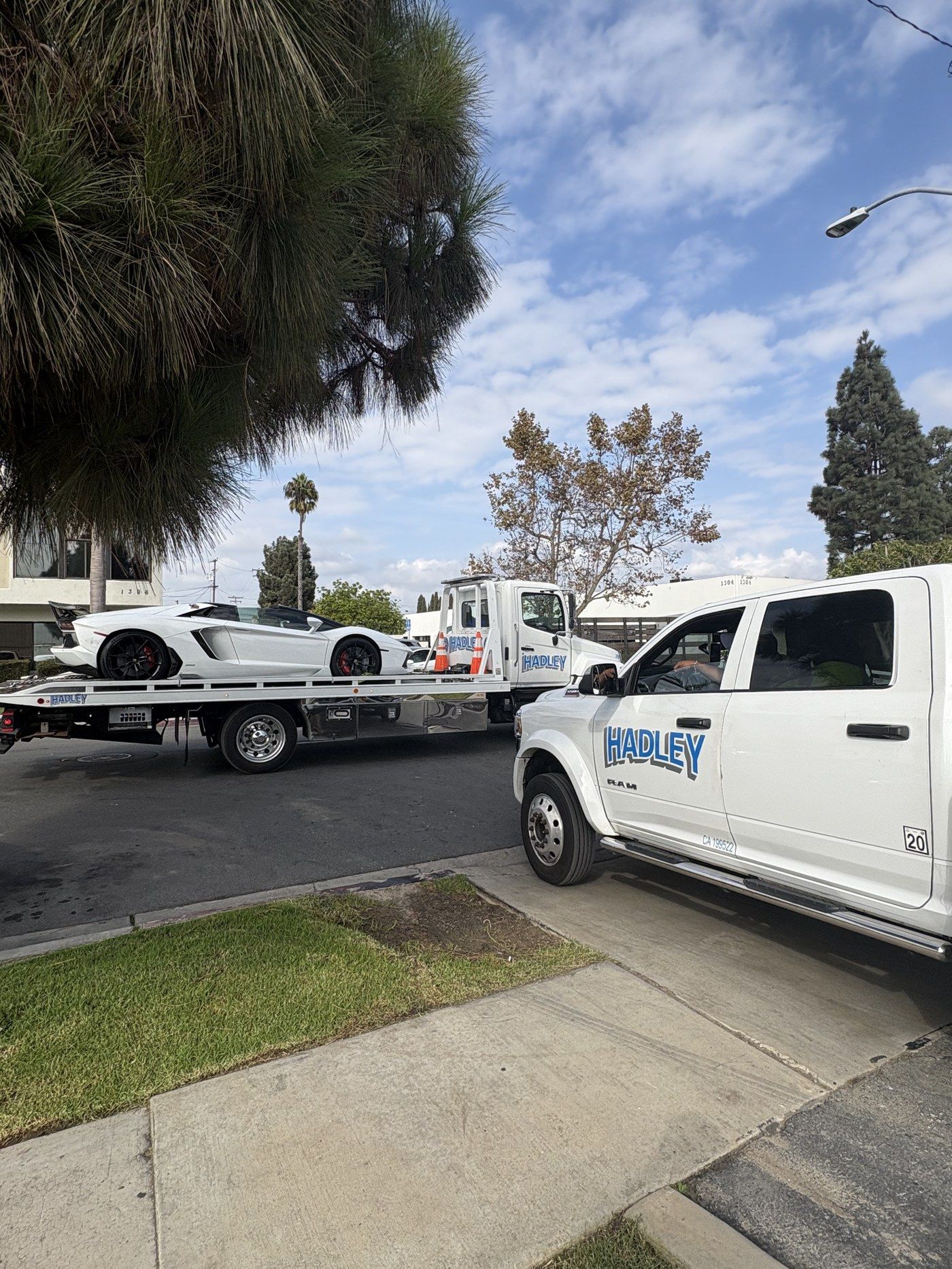 Hadley Tow flatbed transporting a white Lamborghini Aventador in Whittier