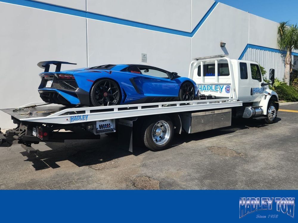 Hadley flatbed transporting a blue Lamborghini Aventador