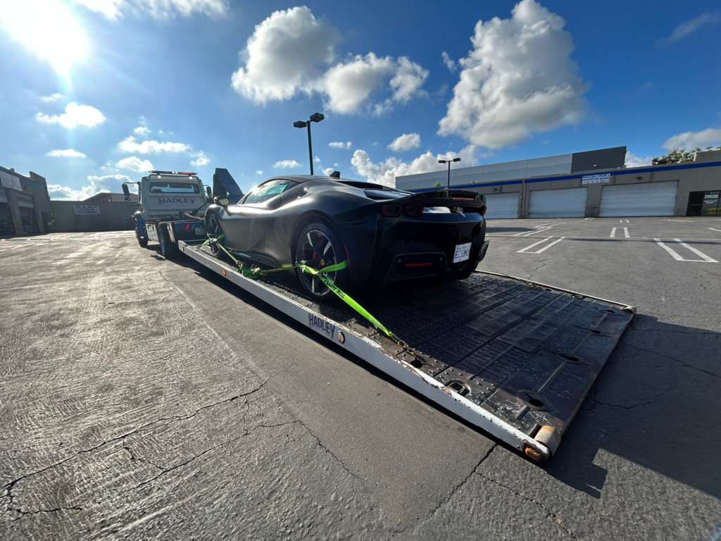 Rear view of Ferrari SF90 on deck against dramatic cloudy sky