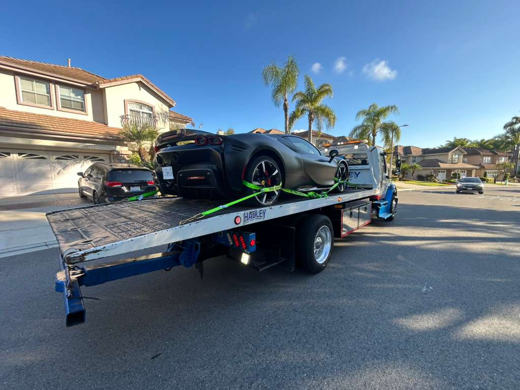 Ferrari SF90 strapped on flatbed tow in SoCal neighborhood