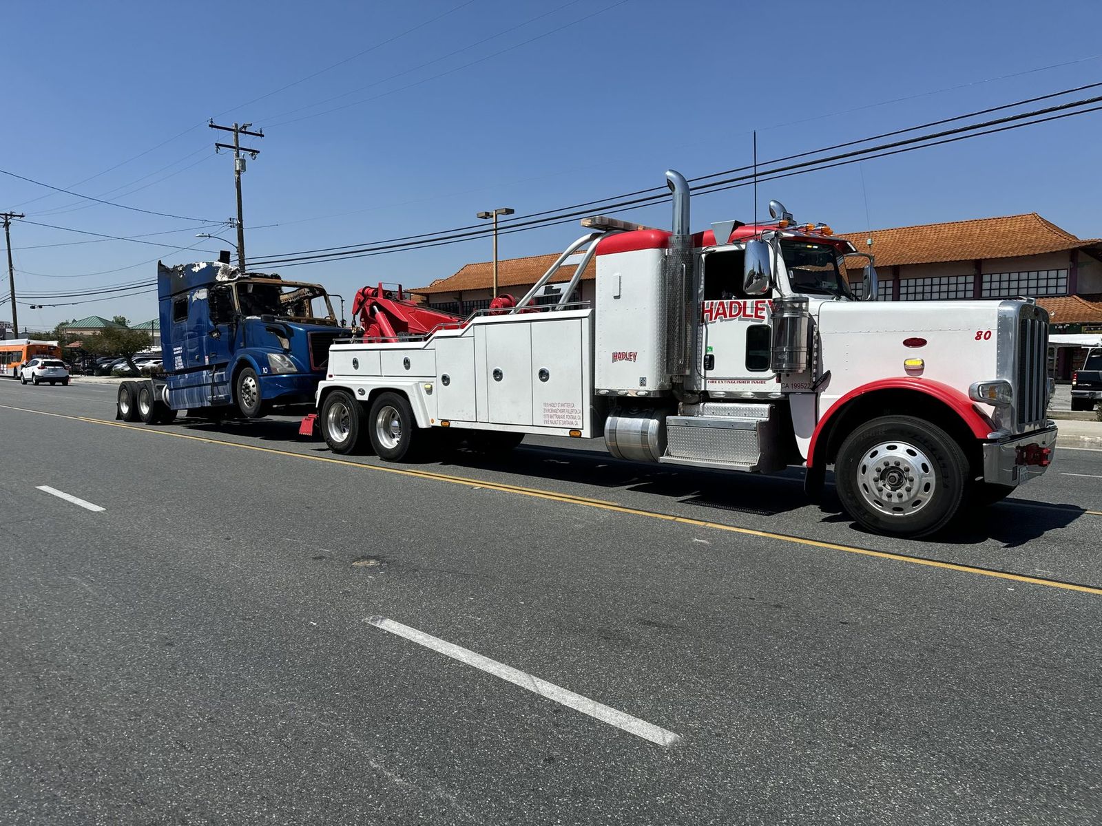 Hadley Peterbilt #80 heavy-duty wrecker under-lifting a crashed Volvo tractor
