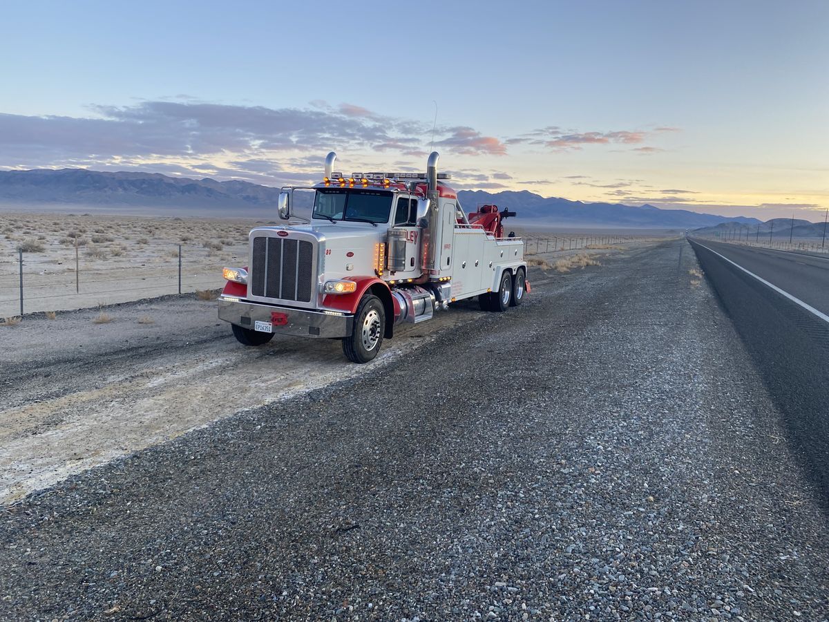 Hadley red-and-white heavy wrecker parked at sunrise on a desert roadside