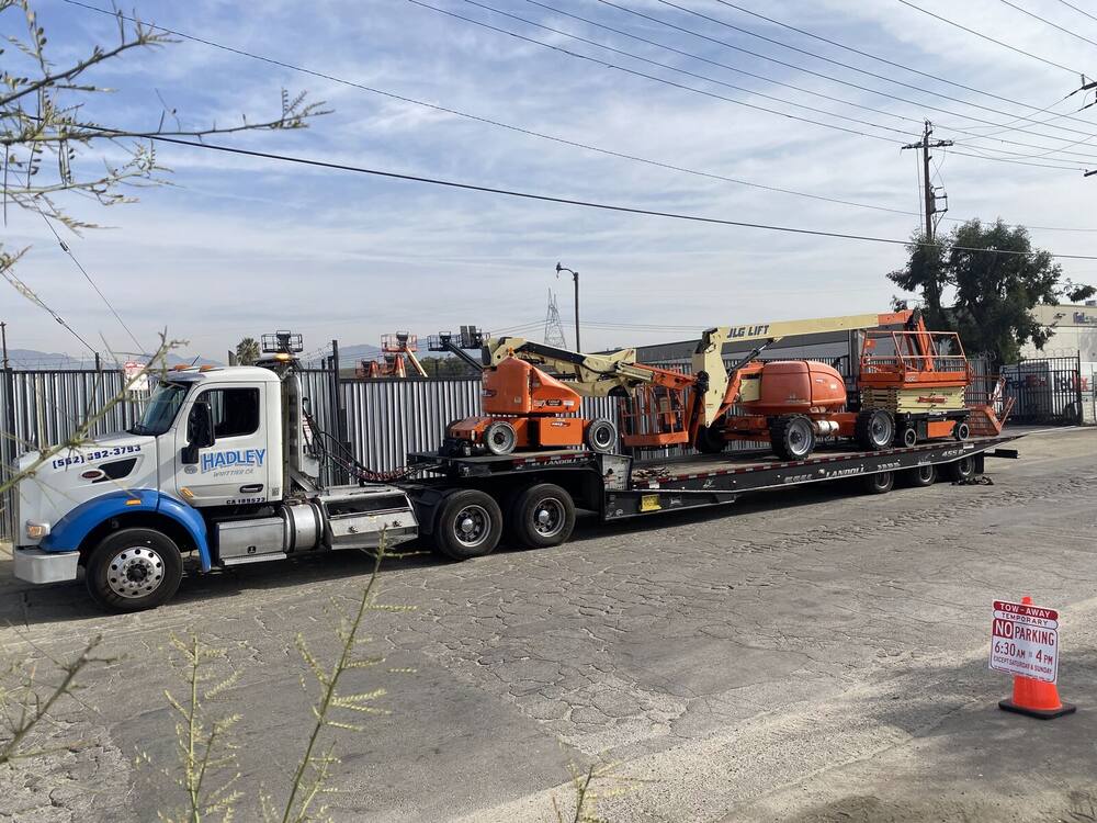 JLG boom lifts on Hadley landoll with no-parking sign